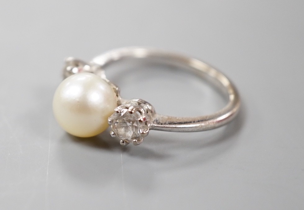 A white metal (stamped plat), single stone diamond and two stone cultured pearl set dress ring, size M, gross weight 4.2 grams.